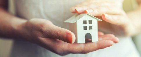 hands holding a model house